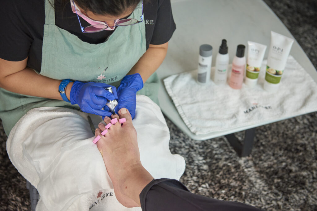 Una especialista aplicando el servicio de pedicura a una persona