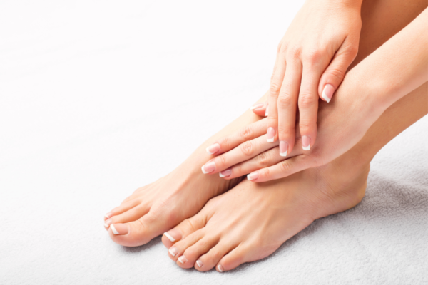 Una persona sentada en el suelo sujetandose los pies